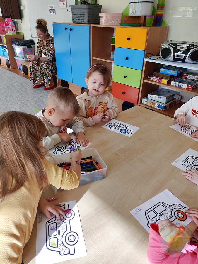 Siedzące dzieci przy przedszkolnym stoliku, wykonują pracę - Przedszkole Samorządowe Nr 2 Pod Słonkiem w Białymstoku
