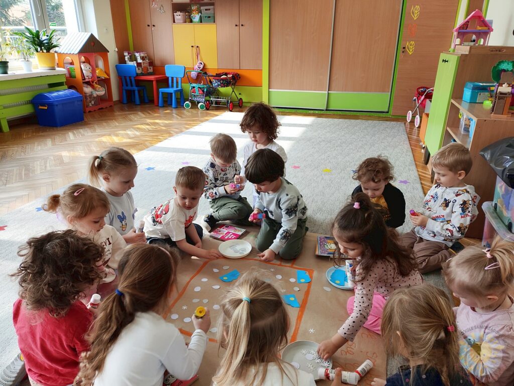 Siedzące dzieci na dywanie, które biorą udział w zajęciach - Przedszkole Samorządowe Nr 2 Pod Słonkiem w Białymstoku