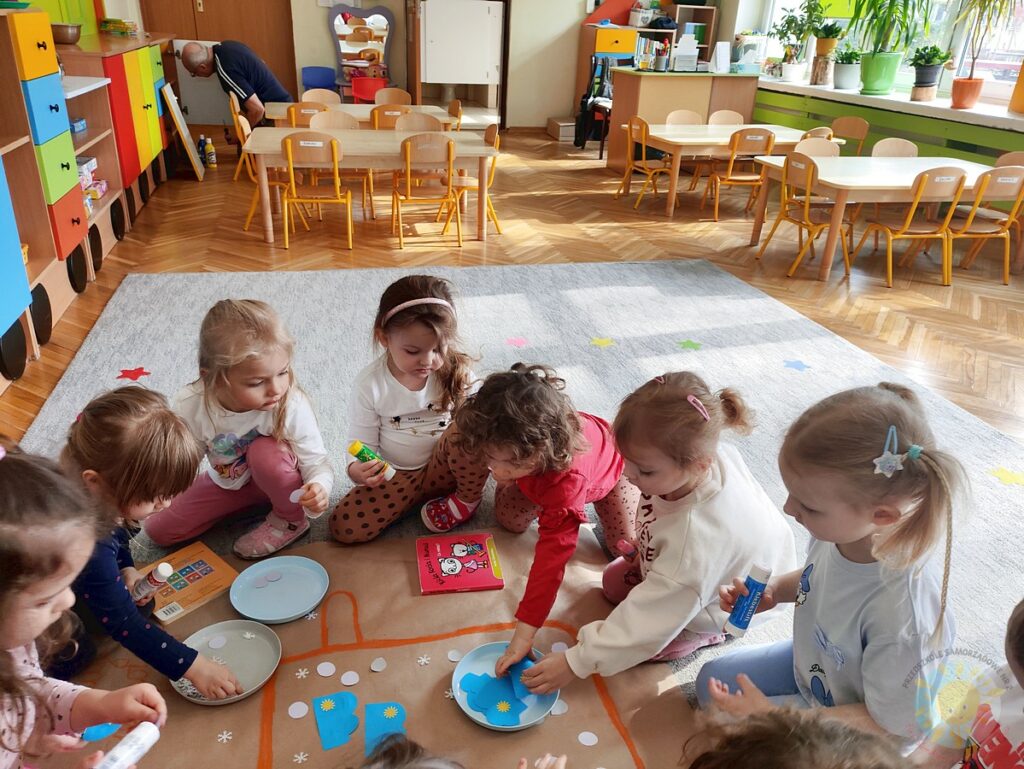 Siedzące dzieci na dywanie, które biorą udział w zajęciach - Przedszkole Samorządowe Nr 2 Pod Słonkiem w Białymstoku