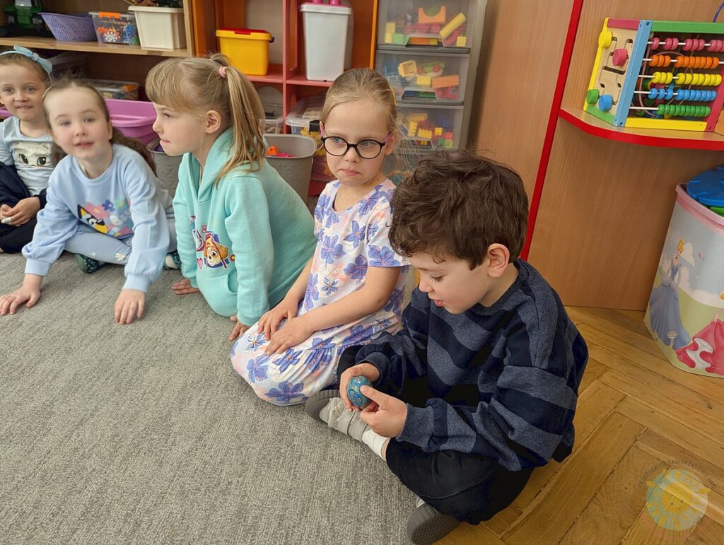 Siedzące dzieci na dywanie, które biorą udział w zajęciach - Przedszkole Samorządowe Nr 2 Pod Słonkiem w Białymstoku