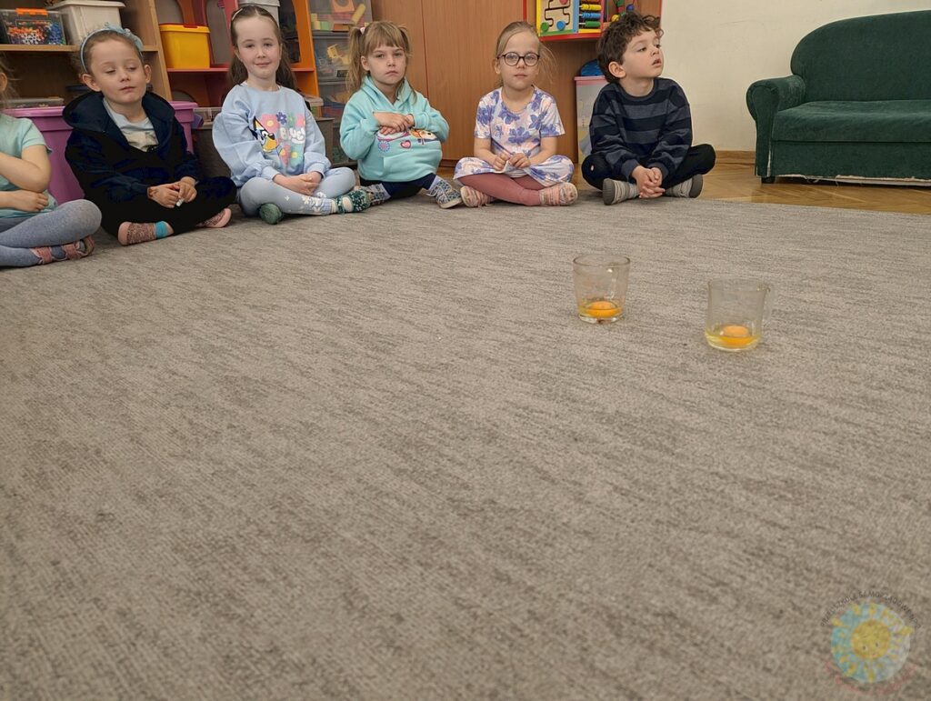 Siedzące dzieci na dywanie, które biorą udział w zajęciach - Przedszkole Samorządowe Nr 2 Pod Słonkiem w Białymstoku