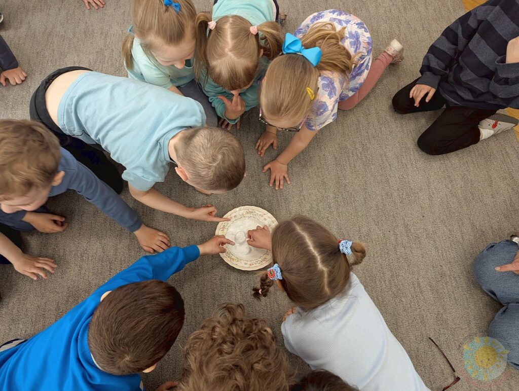 Siedzące dzieci na dywanie, które biorą udział w zajęciach - Przedszkole Samorządowe Nr 2 Pod Słonkiem w Białymstoku