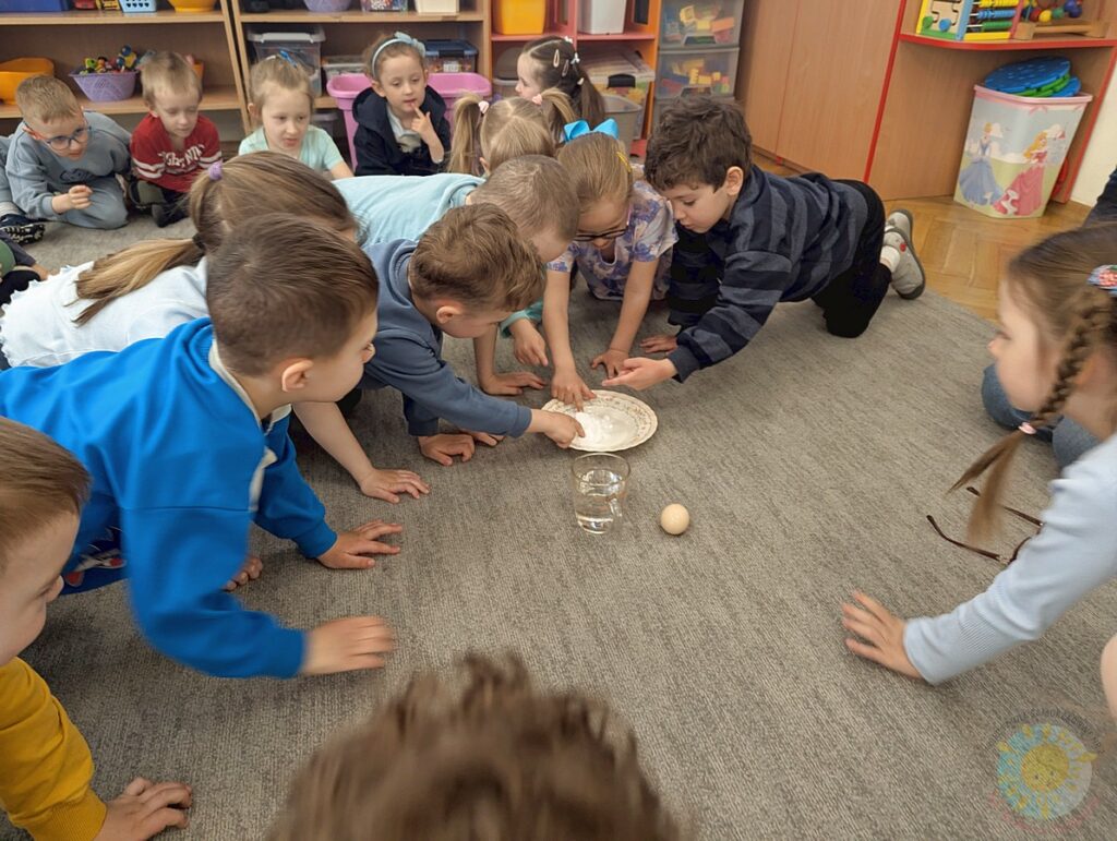 Siedzące dzieci na dywanie, które biorą udział w zajęciach - Przedszkole Samorządowe Nr 2 Pod Słonkiem w Białymstoku