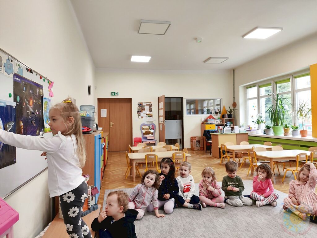 Siedzące dzieci na dywanie, które biorą udział w zajęciach - Przedszkole Samorządowe Nr 2 Pod Słonkiem w Białymstoku
